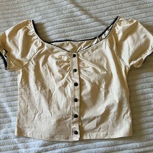 Cream blouse with black lace trim/black buttons.